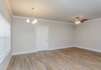 A room with a ceiling fan and a door at Cedar Crest Apartments, Farmington, AR